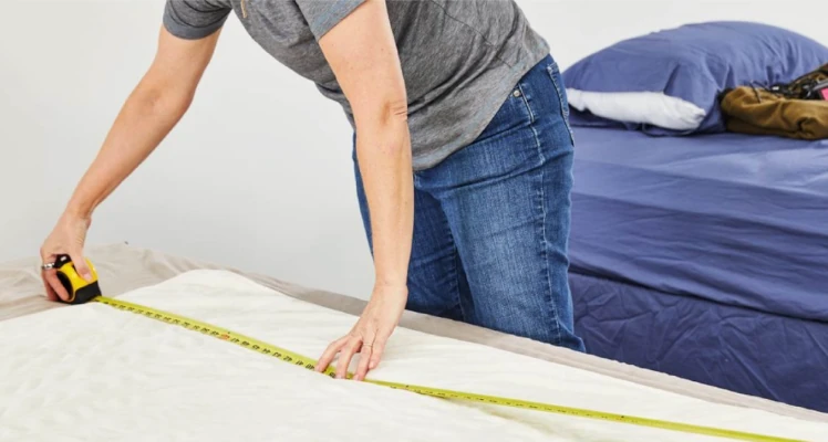 A person physically measuring a piece of furniture