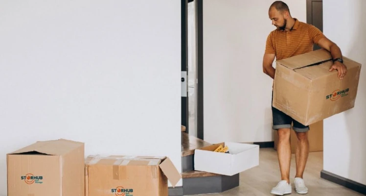 a Man carrying boxes out of his home